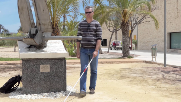 una persona porta el bastón blanco con la herramienta Egara en la superficie del mango