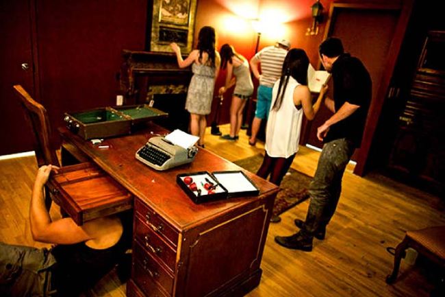 Grupo de amigos dentro de un Escape Room buscando las pistas durante el juego