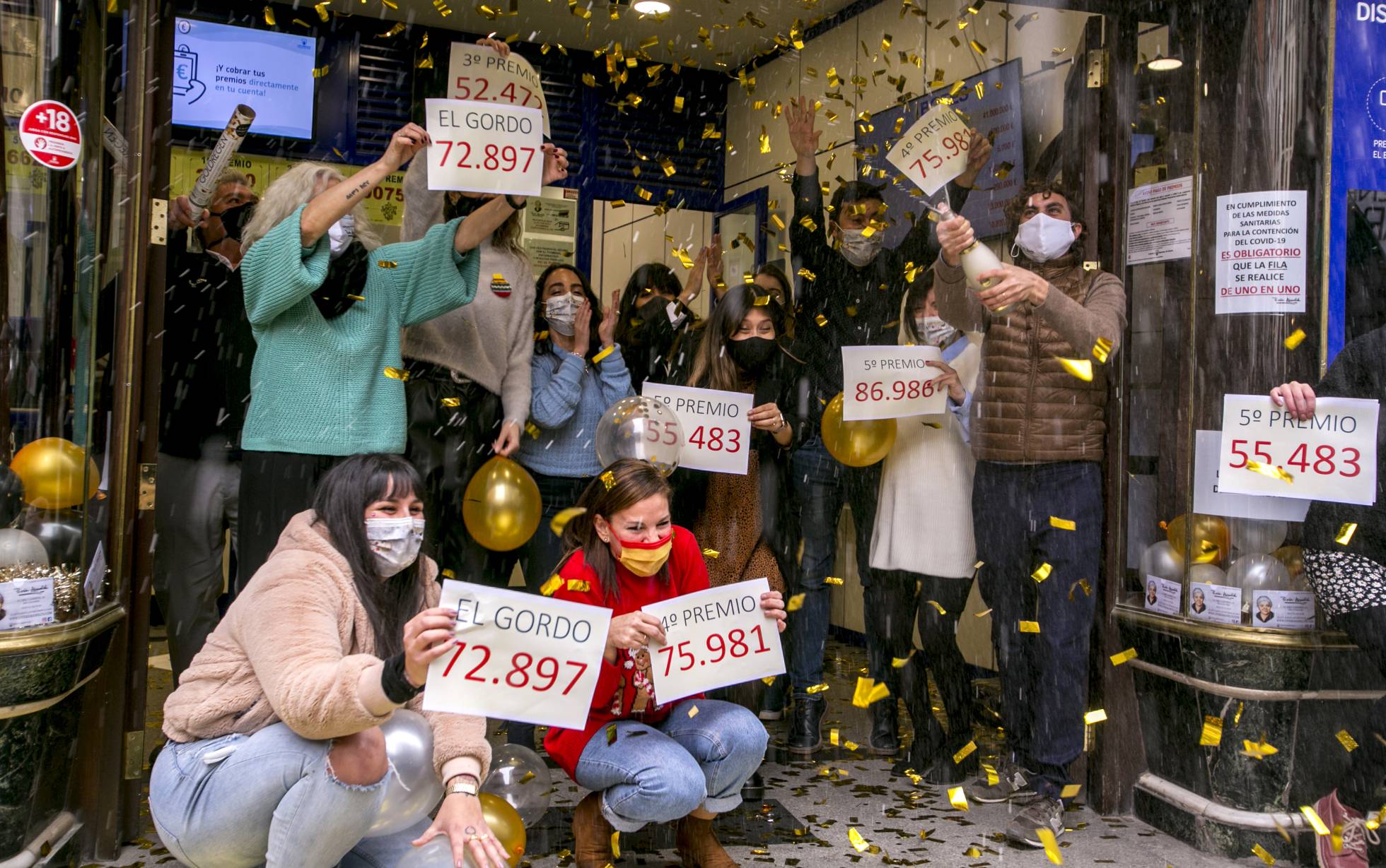 Algunas personas celebran el Gordo de la Lotería / El País 