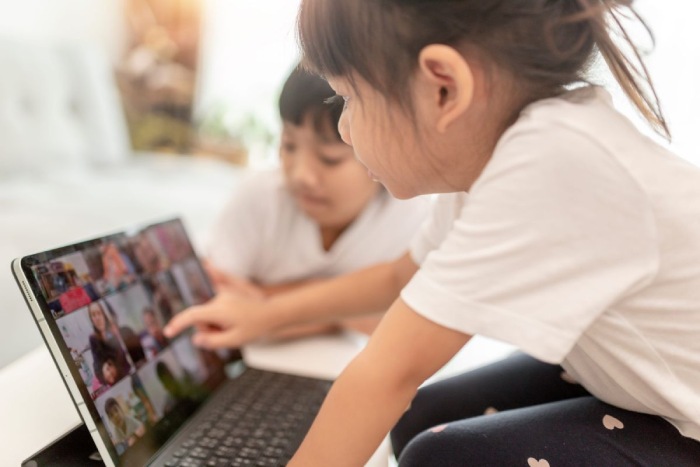Dos niños miran a una pantalla