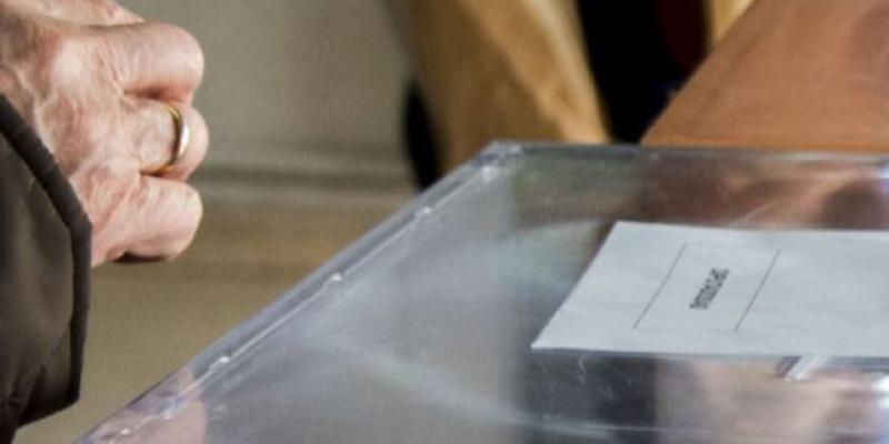 Mano de una persona votando en las urnas de las elecciones