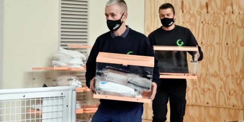 Dos trabajadores transportan urnas en el dispositivo electoral para los comicios catalanes de este domingo, en Barcelona, Catalunya (España), a 13 de febrero de 2021. (ARCHIVO)