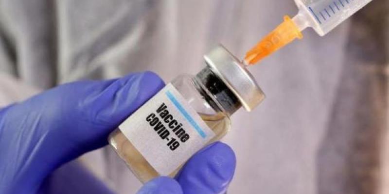 Se sujeta una dosis de la vacuna para la Covid-19 con una mano protegida por un guante de color azul 