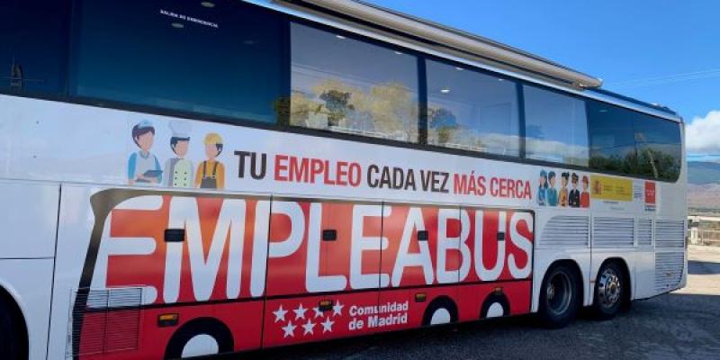 En primer plano el 'EmpleaBus' de la Comunidad de Madrid con grandes rótulos informativos 