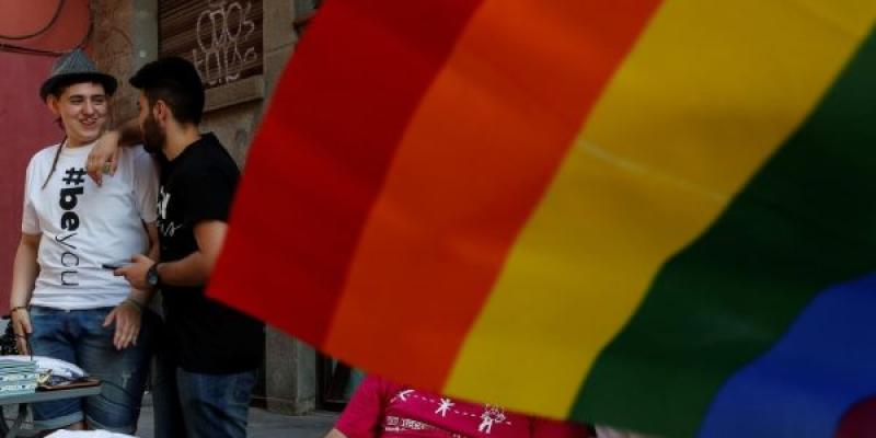 Pareja LGTBI junto a la bandera 