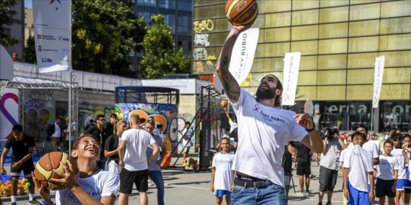 Ricky Rubio juega con los niños participantes en el acto de su fundación en la plaza Terenci Moix de El Raval / JORDI COTRINA