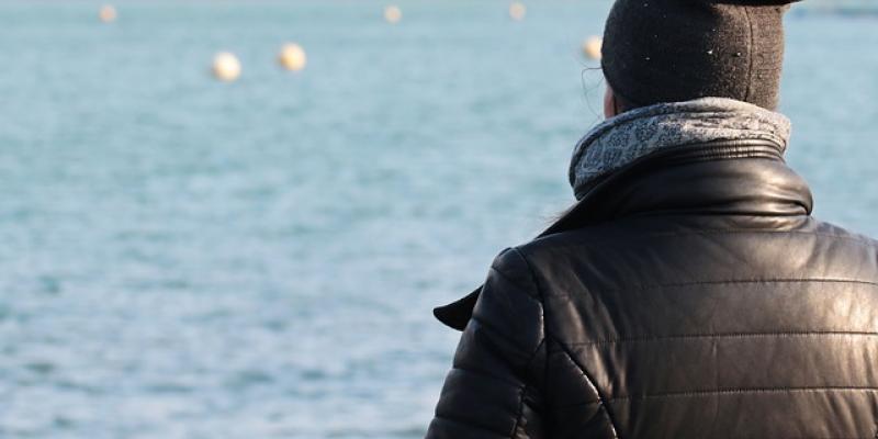 El tiempo estable se queda en España Una mujer, abrigada, mirando a un lago en un día soleado