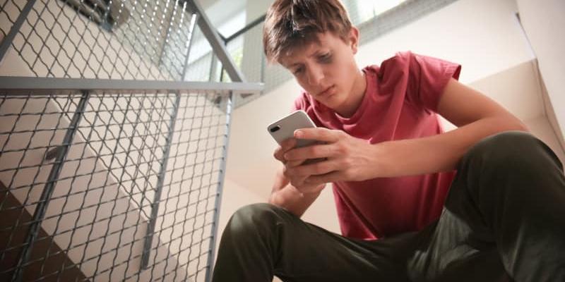 Imagen de un joven con el móvil/Educo La tecnología como aliada contra el acoso