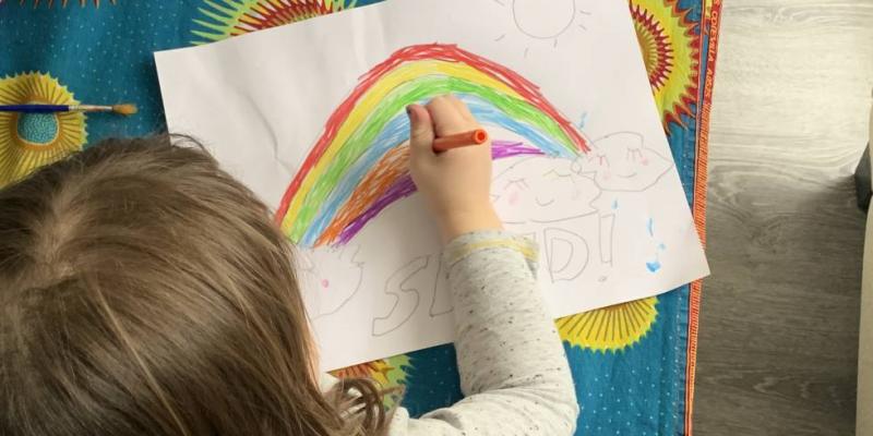 Una niña dibuja un arcoíris. C.G.