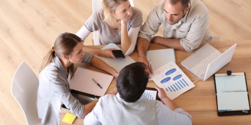 Mesa de trabajo con hombres y mujeres