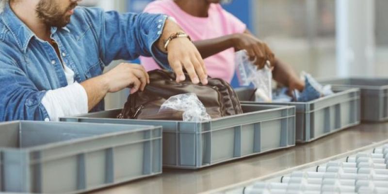 Imagen de dos personas dejando sus enseres en las bandejas del control de aeropuertos/BBC Los aeropuertos incluyen medidas de seguridad para acortar las colas