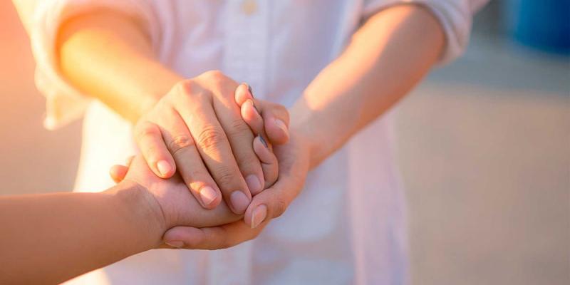 Imagen de dos personas agarrándose de la mano/MédicoPlus Día Internacional del Agradecimiento