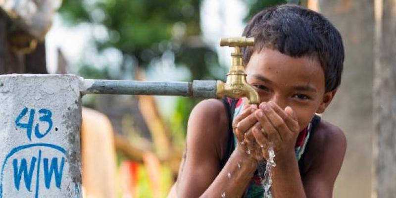 Niño pequeño bebiendo agua limpia