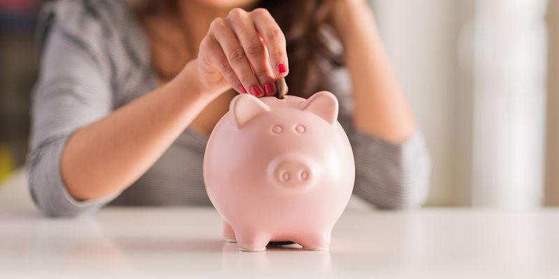 Imagen de una mujer echando monedas a la hucha/Zaplo ¿Cómo podemos ahorrar dinero rápido y fácil?