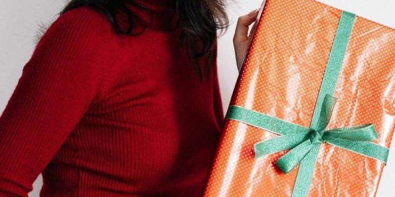Las mejores ideas de regalos para el amigo invisible con las que acertar (Pexels) Chica navideña con un regalo
