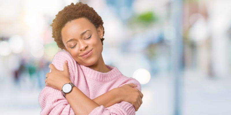Imagen de una chica abrazándose a sí misma/Concepto La Generación Z apenas tiene amor propio