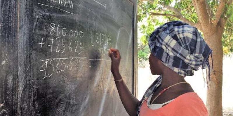 Persona escribiendo en una pizarra de África