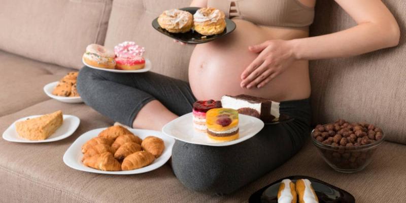 Imagen de una mujer embarazada con alimentos/Ser Padres Antojos en el embarazo, ¿por qué los tienes?
