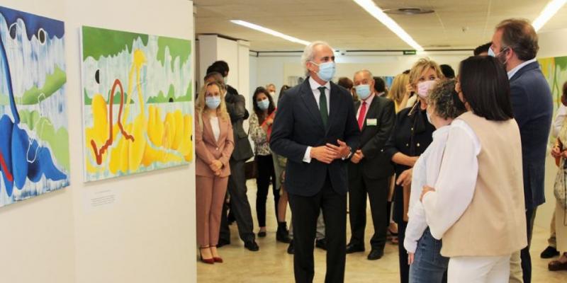 Los organizadores presentando los cuadros en la galeria