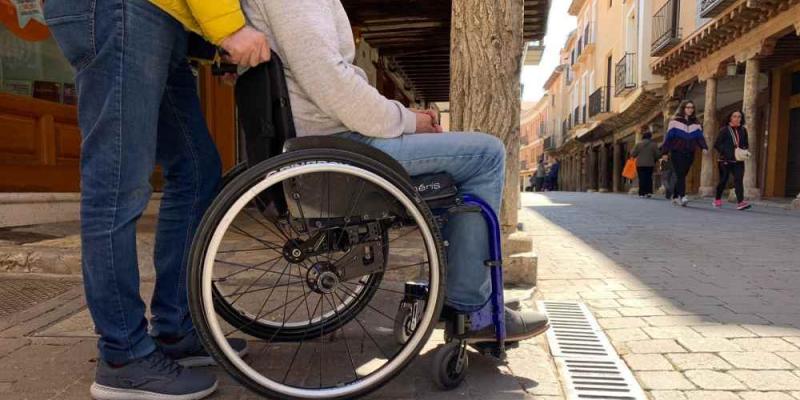 Asistencia personal Predif Persona empujando una silla de ruedas / PREDIF CYL