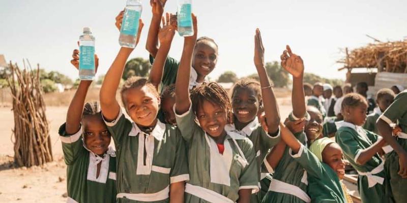 Imagen de niños con botellas de agua/Ciencias Ambientales AUARA lucha por llevar agua a las zonas desfavorecidas