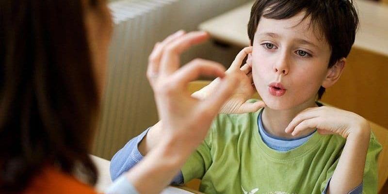 Una maestra da clases a un niño con autismo