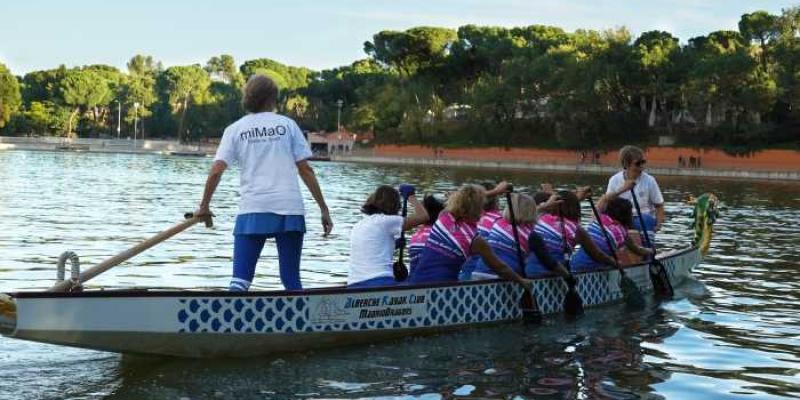 Barco dragón por el cáncer de mama Mujeres remando en el barco dragón por el cáncer de mama