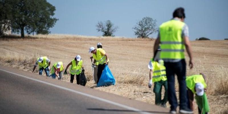 Basura que se tira de los coches en conducción Voluntarios recogiendo la basura de las cunetas