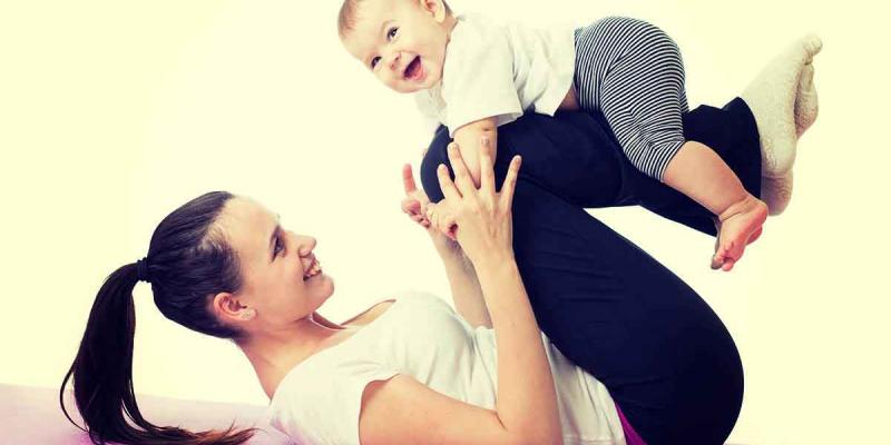 El bebé es feliz haciendo ejercicios al lado de su madre