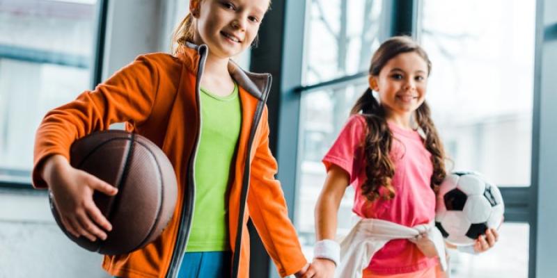 dos niñas con un balón en la mano