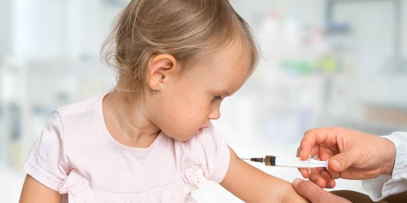 Imagen de una niña poniéndose una vacuna/Bebés y más Calendario de vacunas 2023 para niños