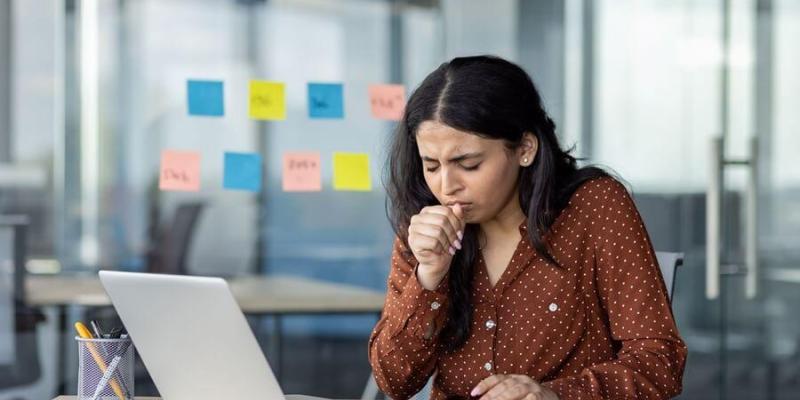 Imagen de una chica tosiendo/Soziable Calidad del aire en los trabajos