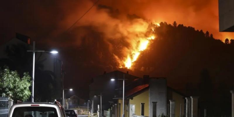 Cambio climático - Foto: EFE Vista de las llamas desde una zona poblada durante un incendio forestal en la provincia de Ourense.