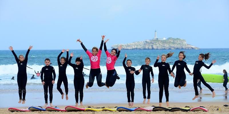 Imagen de un grupo de chicos en un campamento de surf/Juvigo Campamentos de verano para jóvenes 2022