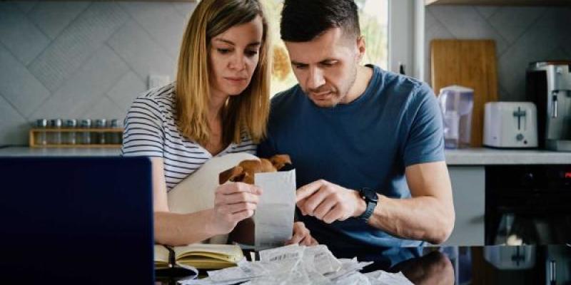 Una pareja mira unos recibos en su casa para presentar la renta 2022