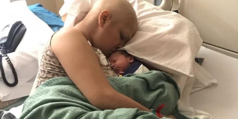 Cáncer de mama durante el embarazo Mujer con cáncer de mama y con su bebé recién nacido