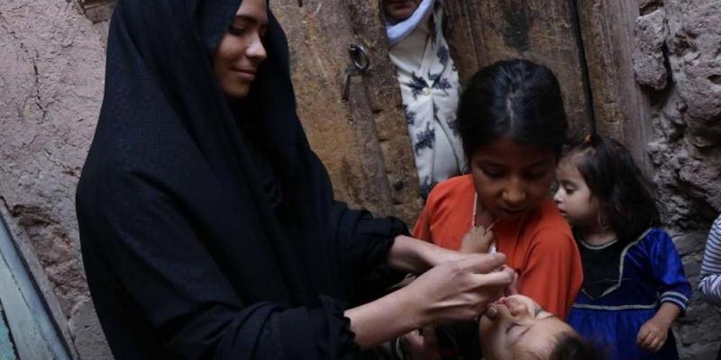 Unos trabajadores sanitarios visitan un hogar para administrar una vacuna contra la polio a los niños en la ciudad de Herat (Afganistan)