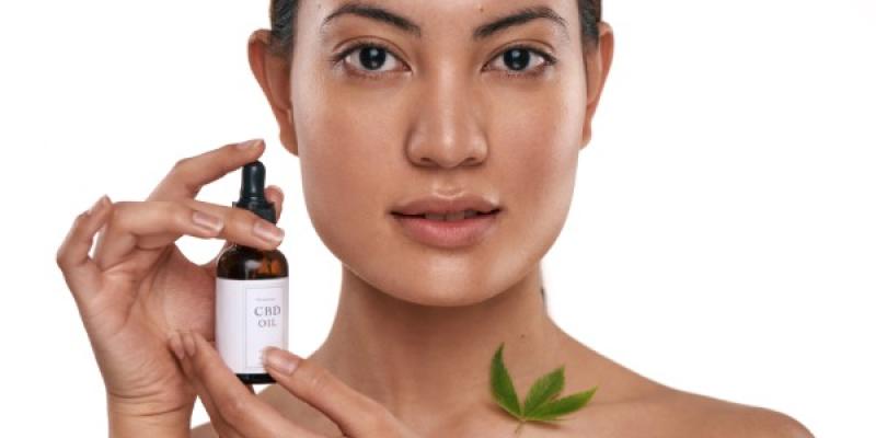 Tienda de cosmética natural con CBD / Envato Rostro de mujer utilizando un producto de cosmética con CBD