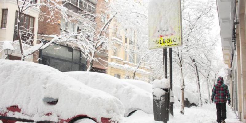 Una persona pasea por una céntrica calle cubierta de nieve junto al acceso de un colegio en Madrid (España) a 9 de enero de 2021.