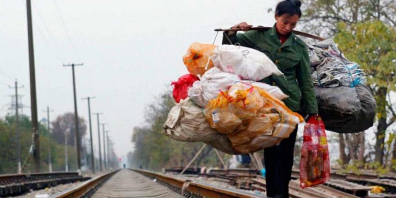 Pobreza extrema en China Un trabajador migrante chino transporta basura por las vías del ferrocarril en diciembre de 2004 en Wuhan, China. // GETTY