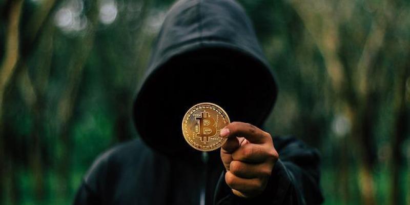 Los criptosecuestradores 'minan' tus criptomonedas - Pixabay Un joven encapuchado sujeta un Bitcoin
