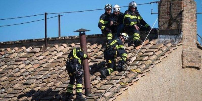El conclave para la elección del nuevo Papa comienza hoy Bomberos italianos colocando la chimenea que tras el cónclave anunciara si hay nuevo Papa
