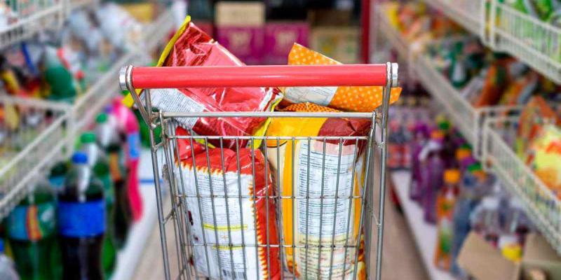 Comida procesada de supermercado - Getty Images/iStockphoto Un carrito de la compra lleno de bolsas de snacks por el pasillo de un supermercado