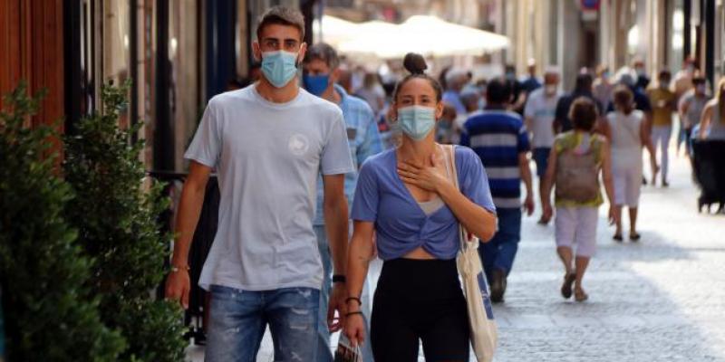 Dos jóvenes caminan con mascarilla por una calle de Reus (Tarragona).