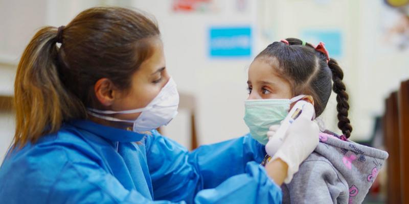 ©UNICEF/Fouad Choufany Una enfermera toma la temperatura a una niña en un Centro de Atención Primaria de Salud en Beirut, Líbano, durante el brote de COVID-19.