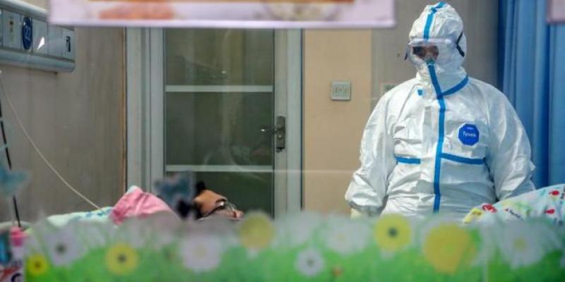 Un médico atiende a un paciente afectado por el coronavirus de Wuhan, en un pabellón de aislamiento de un hospital de la ciudad china. Foto Efe