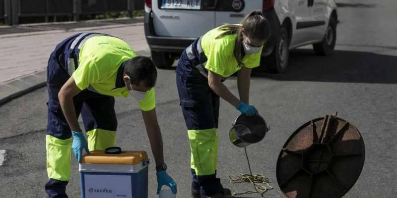 Dos trabajadores durante la recogida de muestras de aguas fecales en una alcantarilla del Miguel Sevet / José Miguel Marco