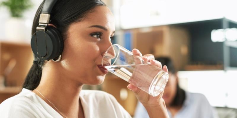 Mujer bebiendo un vaso de agua - Foto: Envato Elements Mujer bebiendo un vaso de agua