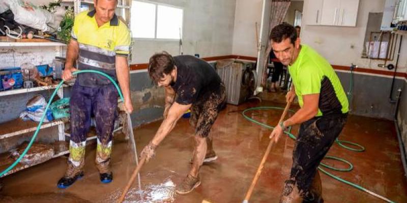 Personas limpiando una casa por efectos de la DANA