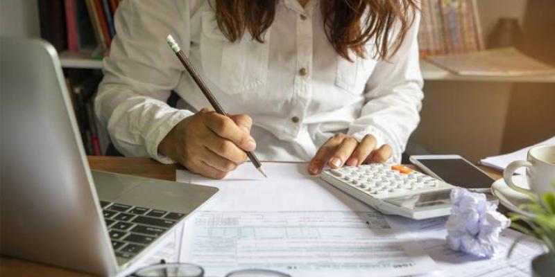Imagen de una mujer con papeles/Cinco Días-El País Cómo hacer la declaración de la renta por Internet